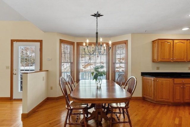 dining area featuring baseboards, plenty of natural light, a chandelier, and light wood-style floors