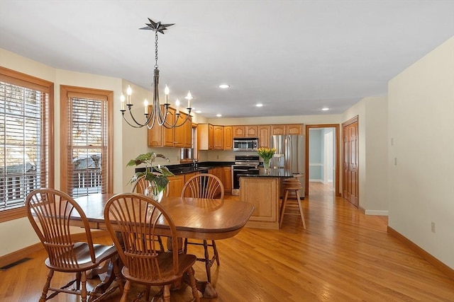 dining room with a notable chandelier, light wood finished floors, recessed lighting, visible vents, and baseboards