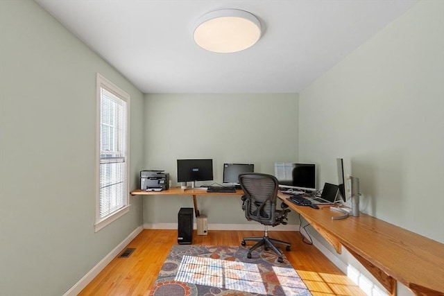 office featuring light wood-type flooring, visible vents, plenty of natural light, and baseboards