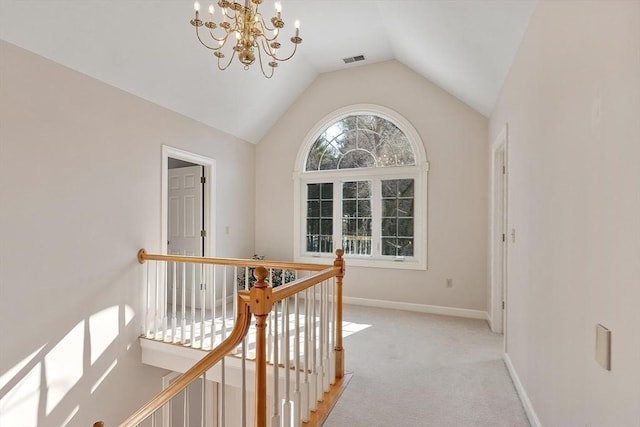 corridor with baseboards, light colored carpet, an inviting chandelier, vaulted ceiling, and an upstairs landing