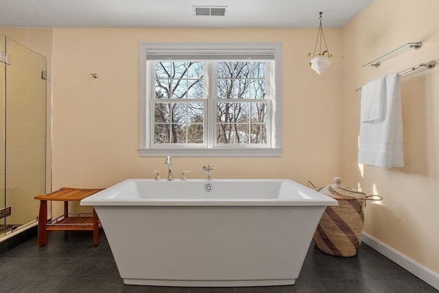 full bathroom featuring visible vents, a freestanding bath, a shower stall, baseboards, and tile patterned floors