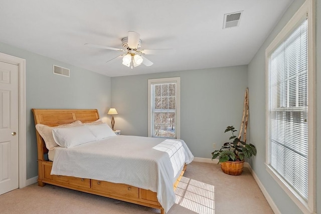 bedroom featuring light carpet, baseboards, visible vents, and a ceiling fan