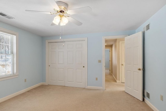 unfurnished bedroom featuring light carpet, baseboards, visible vents, and a closet