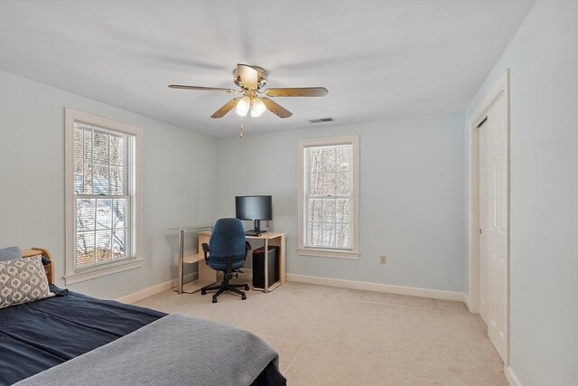 bedroom featuring light carpet, a ceiling fan, visible vents, and baseboards