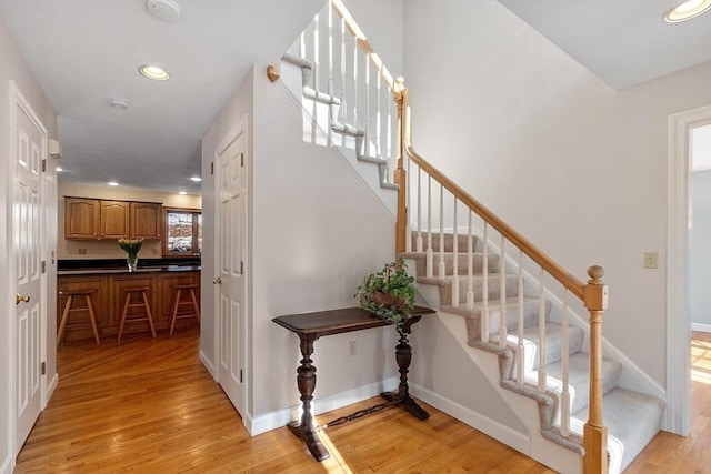 stairway with recessed lighting, baseboards, and wood finished floors