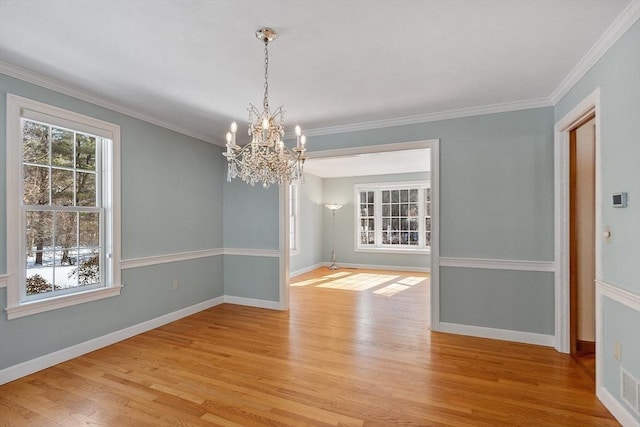 unfurnished dining area featuring light wood-style flooring, baseboards, and crown molding