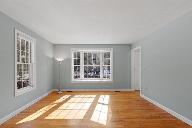 spare room with light wood-type flooring and baseboards