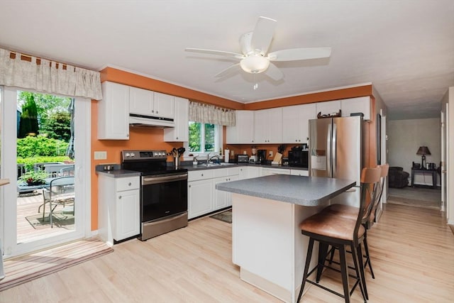 6 Gentry Ln, Taunton, MA 02780 - kitchen with appliances with stainless steel finishes, under cabinet range hood, dark countertops, and light wood finished floors