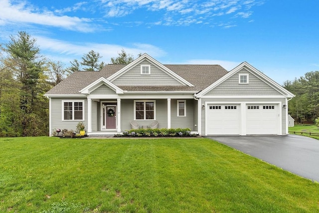 craftsman inspired home with asphalt driveway, a garage, a front yard, and roof with shingles