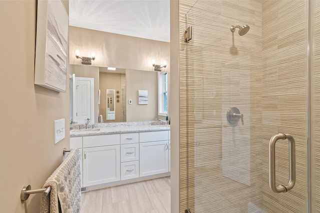 bathroom featuring a stall shower and double vanity