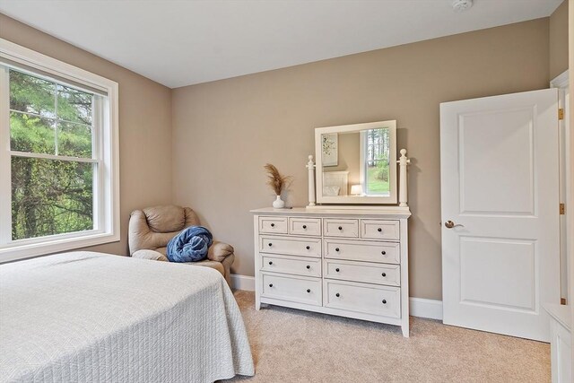 bedroom featuring light carpet and baseboards