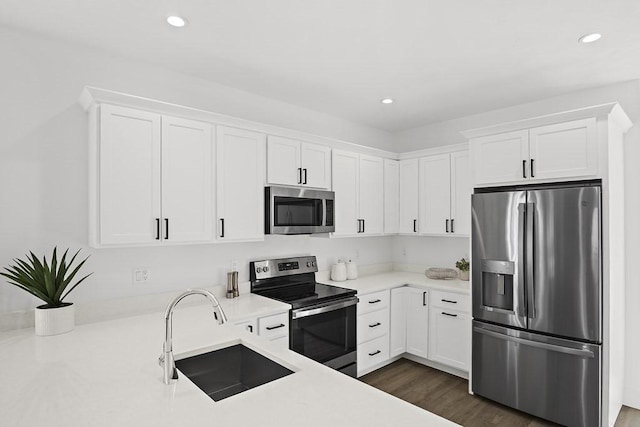 kitchen featuring appliances with stainless steel finishes, white cabinetry, and sink