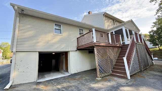 13 Ridgewood Cir, Lawrence, NY 10843 - rear view of property featuring a deck, a garage, a chimney, and stairway