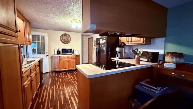 13 Ridgewood Cir, Lawrence, NY 10843 - kitchen featuring black appliances, a peninsula, light countertops, dark wood-style flooring, and a textured ceiling