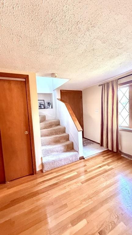 13 Ridgewood Cir, Lawrence, NY 10843 - stairs featuring a textured ceiling and wood finished floors