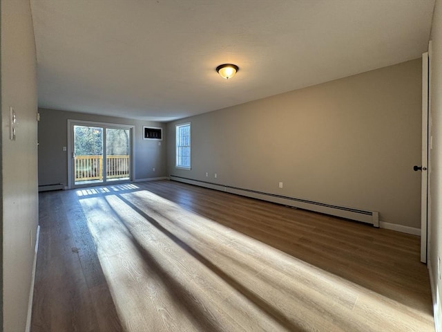 empty room with hardwood / wood-style floors and a baseboard radiator