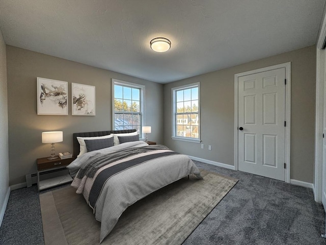 bedroom featuring a textured ceiling, dark carpet, and baseboard heating