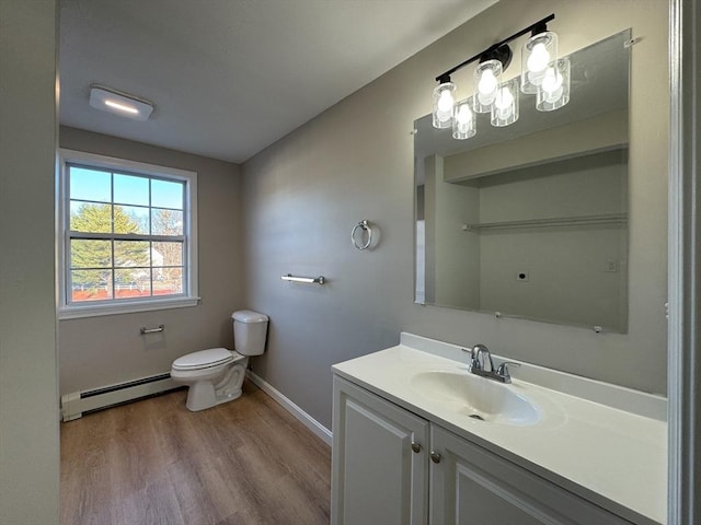 bathroom with wood-type flooring, vanity, toilet, and baseboard heating