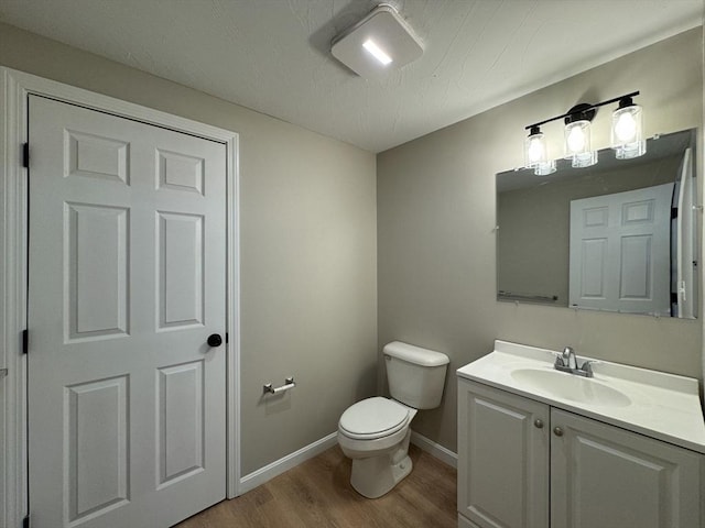 bathroom featuring vanity, toilet, and wood-type flooring