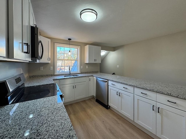 kitchen with sink, light hardwood / wood-style flooring, pendant lighting, white cabinets, and appliances with stainless steel finishes