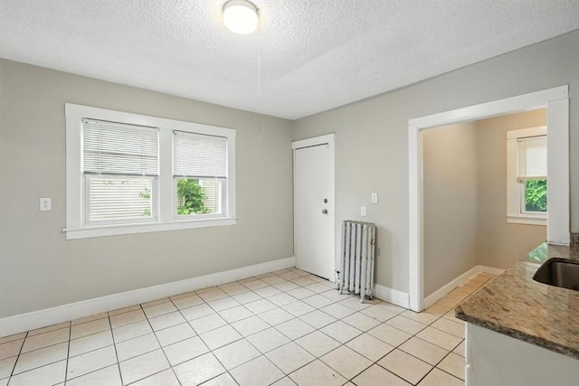 31-33 Dorset St, Springfield, MA 01108 - unfurnished dining area featuring radiator heating unit, a textured ceiling, and light tile patterned floors