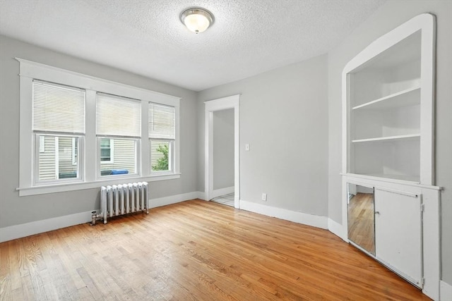 31-33 Dorset St, Springfield, MA 01108 - unfurnished room featuring radiator, light wood-style flooring, and a textured ceiling