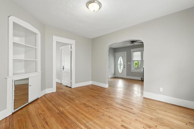 31-33 Dorset St, Springfield, MA 01108 - empty room with arched walkways, a textured ceiling, light wood-style floors, and ceiling fan