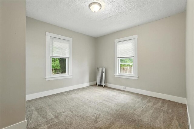31-33 Dorset St, Springfield, MA 01108 - carpeted spare room featuring radiator heating unit and a textured ceiling