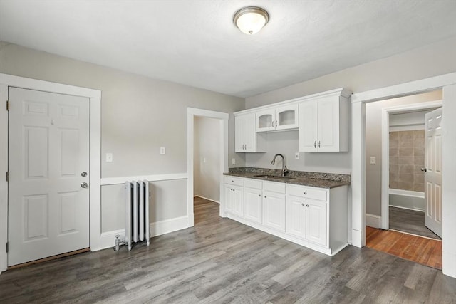 31-33 Dorset St, Springfield, MA 01108 - kitchen featuring radiator, dark wood finished floors, white cabinets, and glass insert cabinets