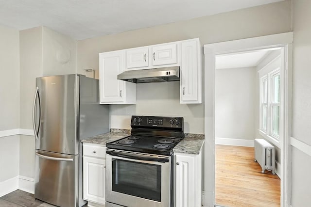 31-33 Dorset St, Springfield, MA 01108 - kitchen with appliances with stainless steel finishes, under cabinet range hood, radiator, light wood finished floors, and white cabinetry