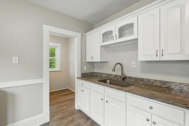 31-33 Dorset St, Springfield, MA 01108 - kitchen featuring white cabinetry, dark stone counters, dark wood-type flooring, and glass insert cabinets