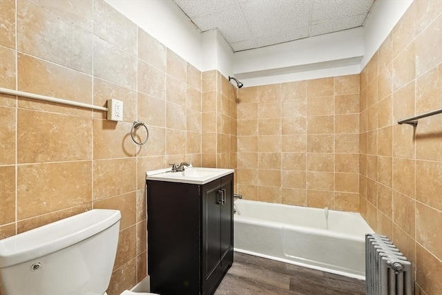 31-33 Dorset St, Springfield, MA 01108 - full bathroom with radiator, tile walls, wood finished floors, washtub / shower combination, and vanity