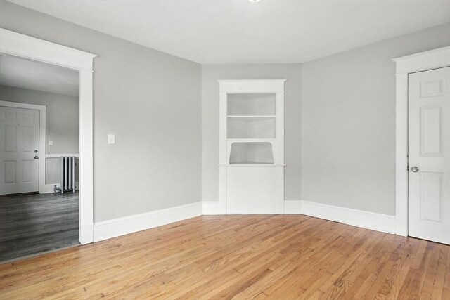 31-33 Dorset St, Springfield, MA 01108 - empty room featuring wood finished floors, radiator, and built in shelves