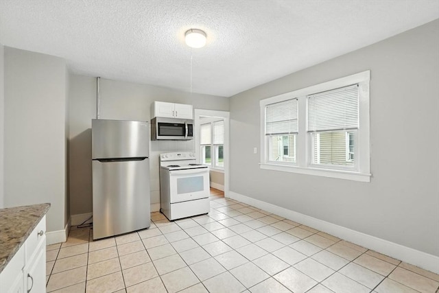 31-33 Dorset St, Springfield, MA 01108 - kitchen with appliances with stainless steel finishes, white cabinetry, a textured ceiling, light tile patterned flooring, and stone countertops