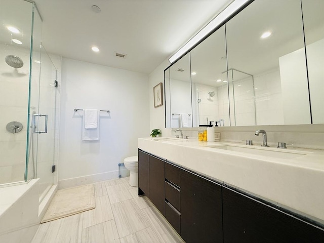 bathroom with vanity, a shower with shower door, and toilet