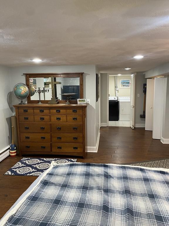 unfurnished bedroom with washer / dryer, dark hardwood / wood-style floors, and ensuite bath