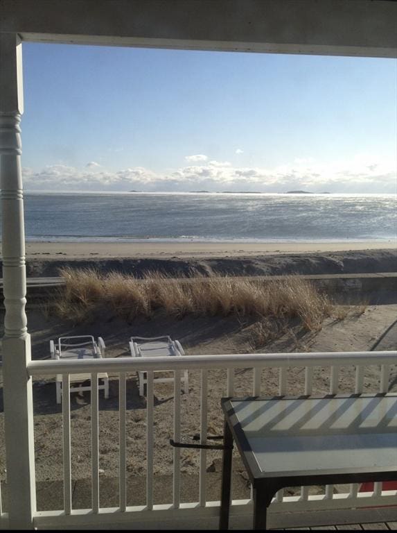 balcony featuring a water view and a view of the beach