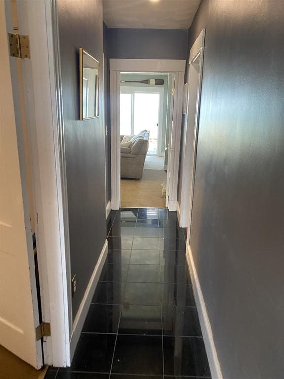 hall featuring dark tile patterned floors