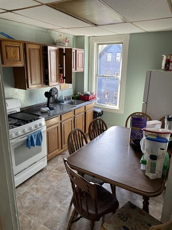 kitchen featuring sink, white appliances, and a drop ceiling