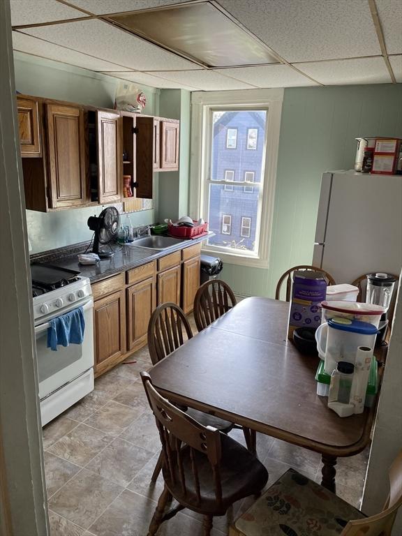 kitchen with sink, white appliances, and a paneled ceiling