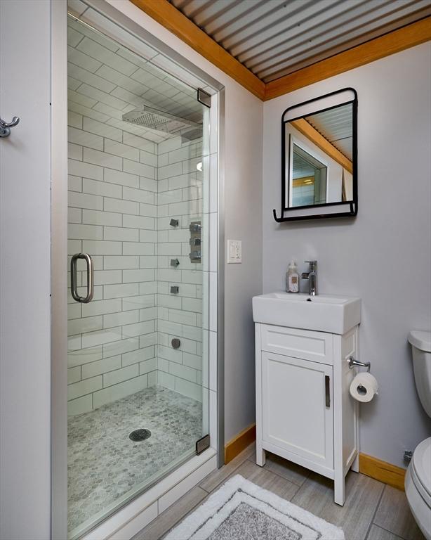 43 Ridge Rd, Erving, MA 01344 - bathroom with a stall shower, toilet, baseboards, vanity, and wood finished floors