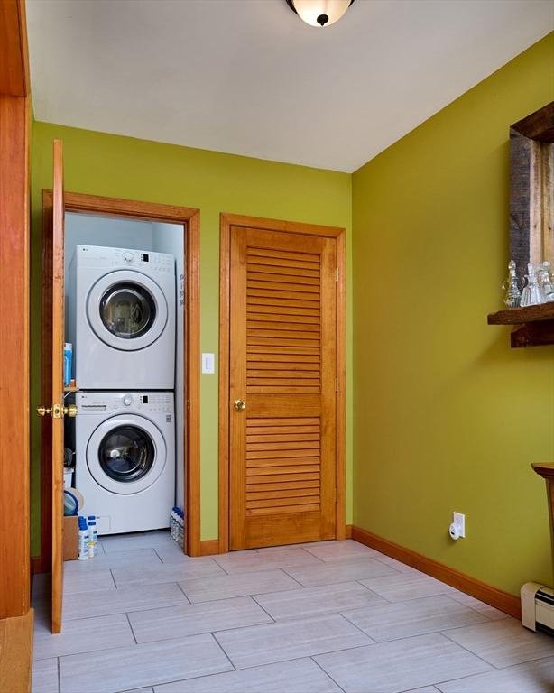 43 Ridge Rd, Erving, MA 01344 - washroom featuring stacked washing machine and dryer, baseboard heating, and baseboards