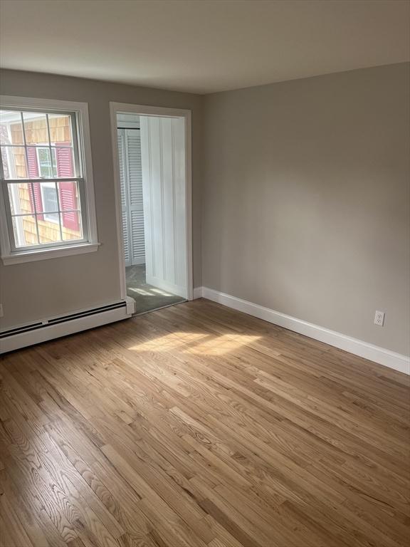 23 Town Hall Ave, Yarmouth, MA 02664 - empty room featuring a baseboard heating unit, baseboards, and wood finished floors