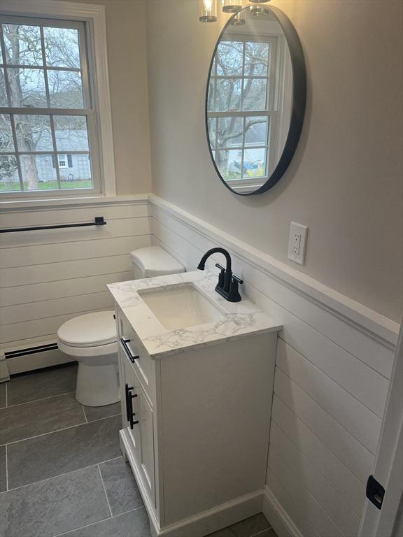 23 Town Hall Ave, Yarmouth, MA 02664 - half bathroom with wainscoting, toilet, vanity, and baseboard heating
