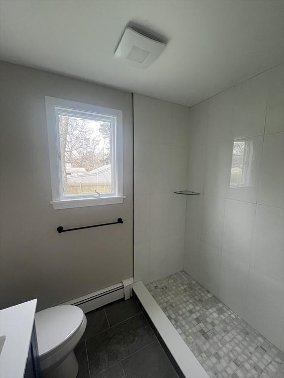 23 Town Hall Ave, Yarmouth, MA 02664 - full bath featuring a baseboard heating unit, vanity, a tile shower, toilet, and tile patterned flooring