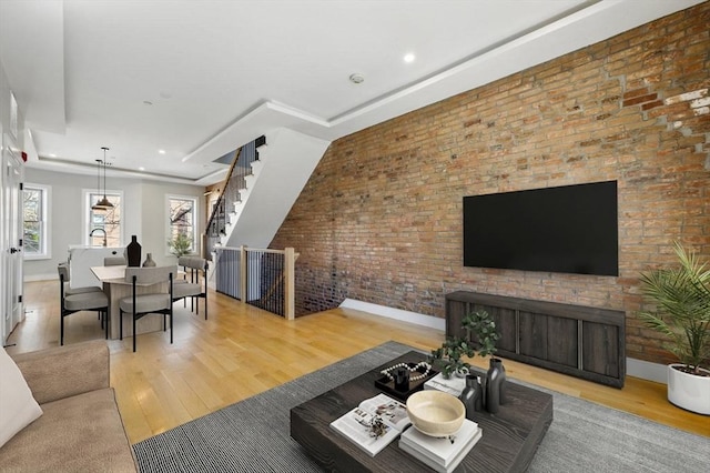 living area with baseboards, recessed lighting, wood finished floors, and stairway