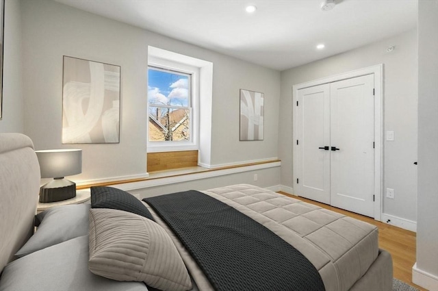bedroom featuring baseboards, a closet, recessed lighting, and wood finished floors