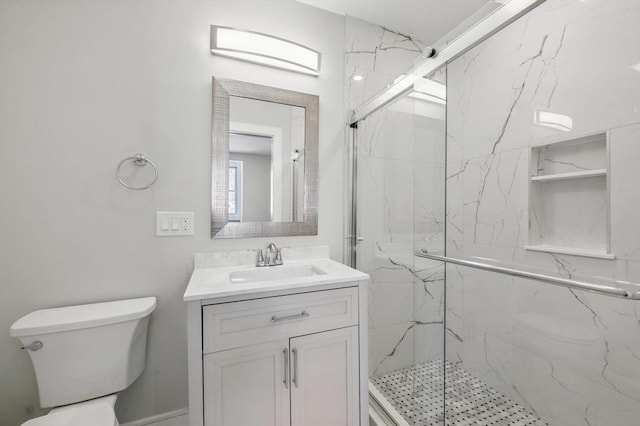 full bath with vanity, a marble finish shower, and toilet