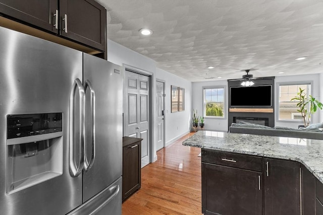 12 School St Unit 3, Salem, MA 01970 - kitchen with stainless steel fridge with ice dispenser, ceiling fan, a fireplace, open floor plan, and dark brown cabinets