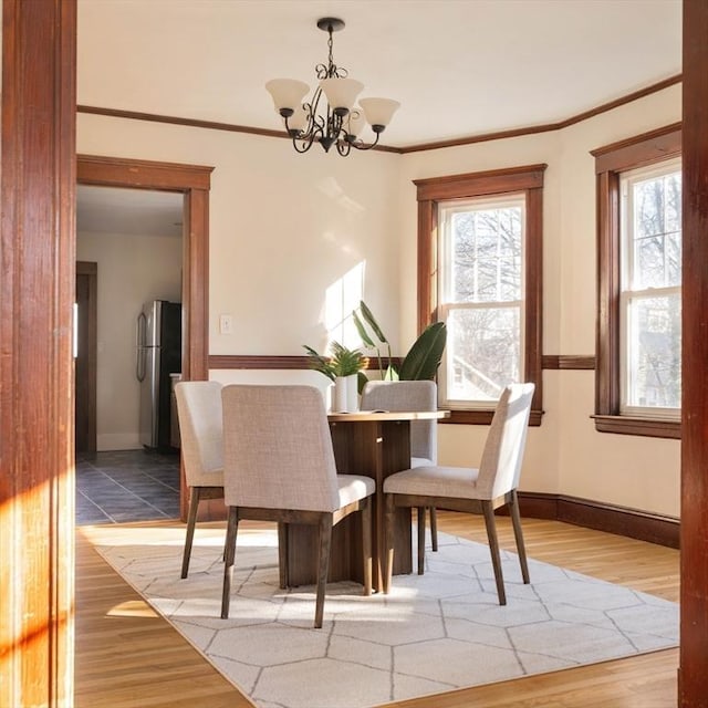 dining area featuring a chandelier, crown molding, and wood-type flooring